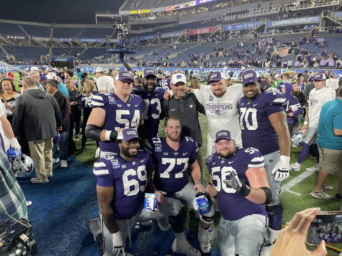 K-State offensive linemen celebrate with interim offensive coordinator Conor Riley after winning the Pop-Tarts Bowl over NC State on Dec. 28, 2023.
