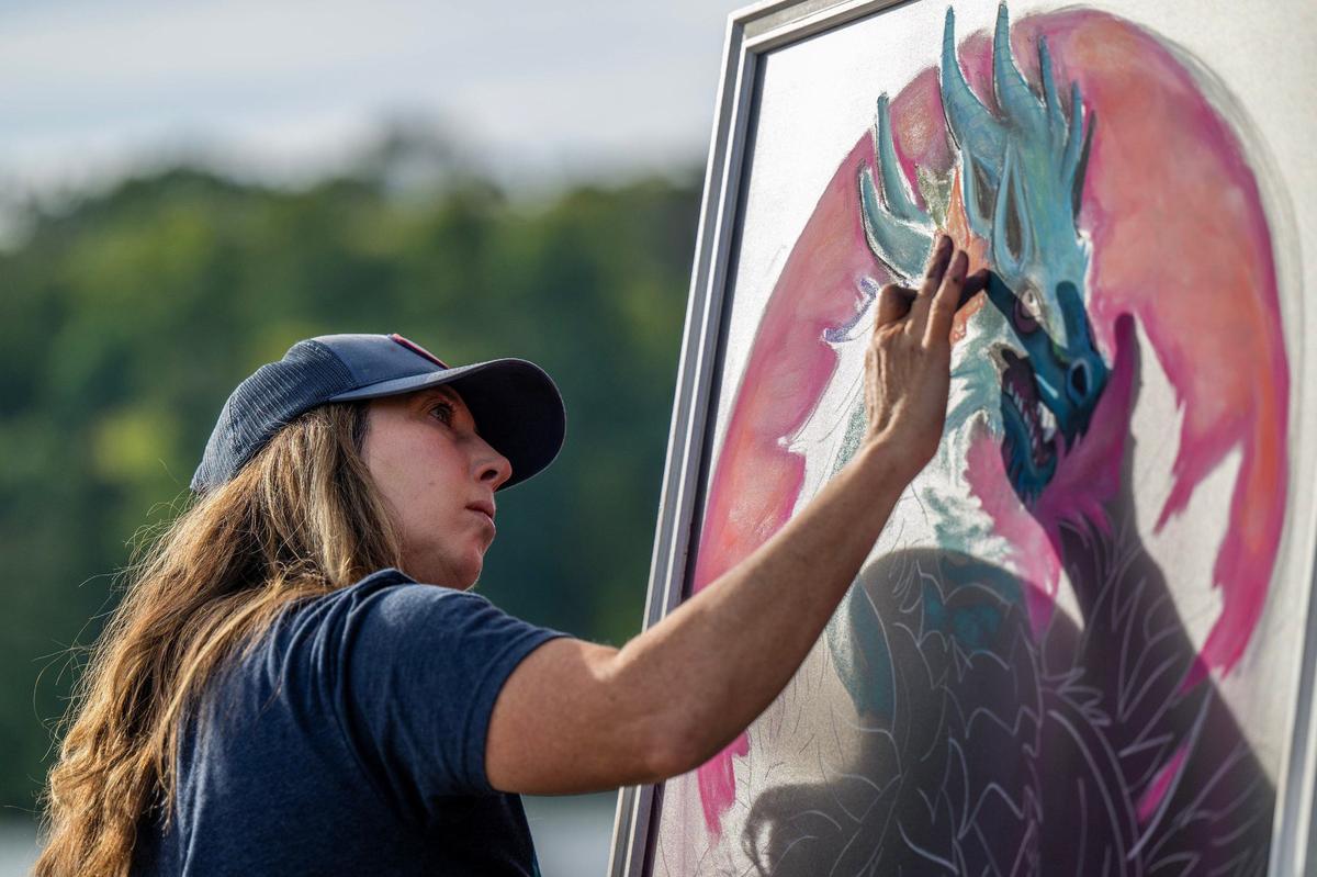 Chalk artist Amy Lynn Sell sketches a dragon during the KC Dragon Boat Festival on Saturday, Sept. 28, 2024, near the marina at Shawnee Mission Park.