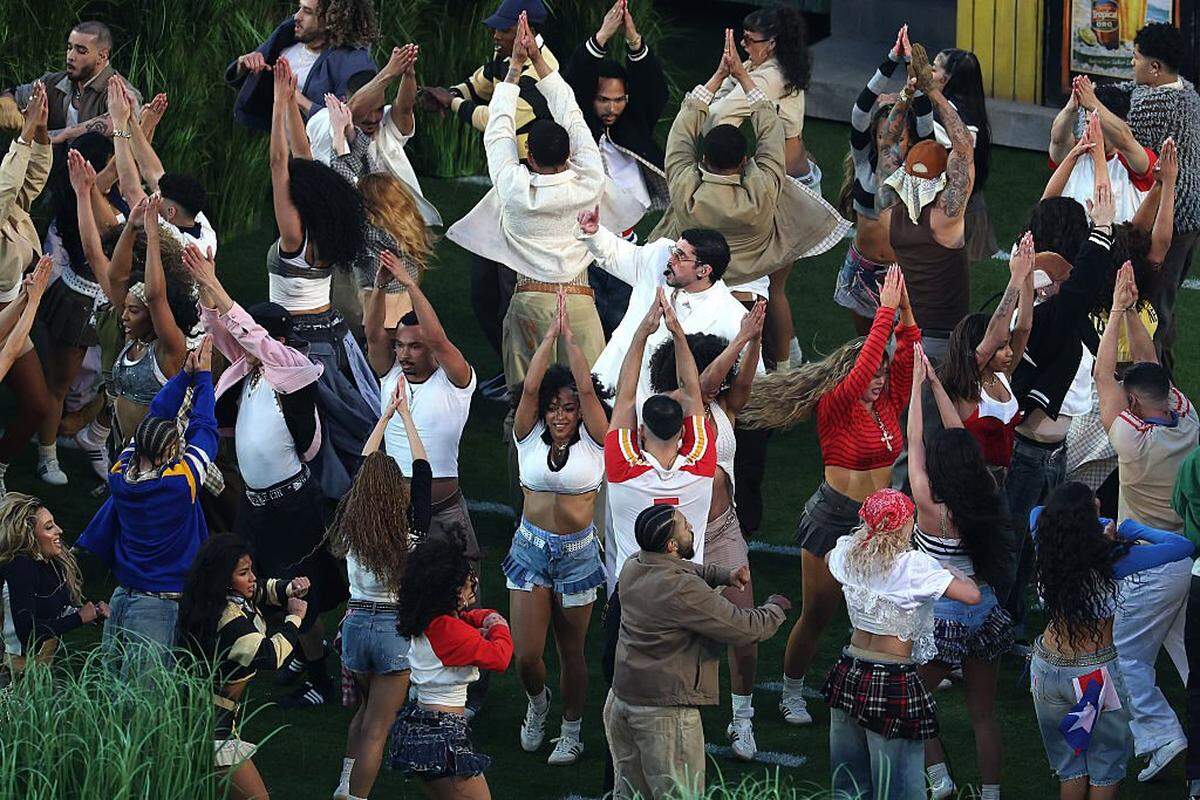 SANTA CLARA, CALIFORNIA - FEBRUARY 08: Bad Bunny performs onstage during the Apple Music Super Bowl LX Halftime Show at Levi's Stadium on February 08, 2026 in Santa Clara, California. Logan Lanigan (red striped shirt) was one of the dancers who performed alongside the Puerto Rican superstar. (Photo by Ishika Samant/Getty Images)