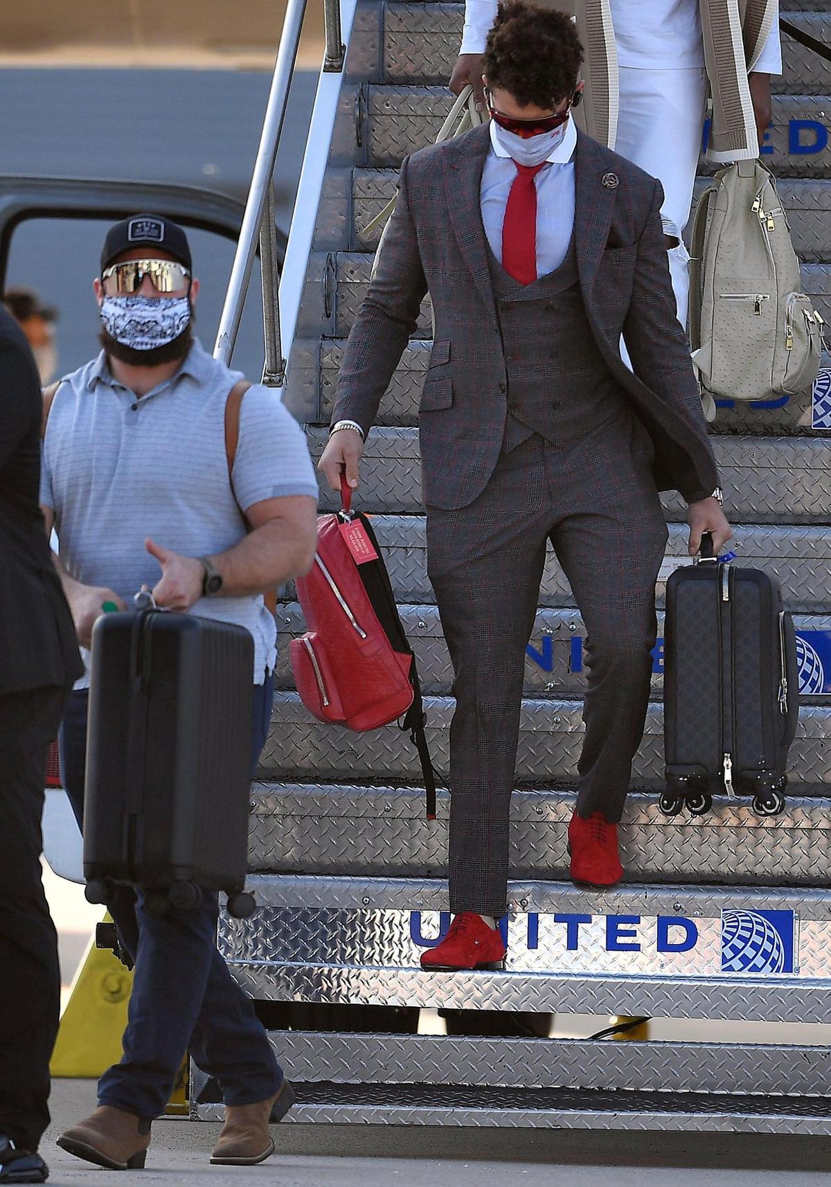 Complete with red suede shoes, Kansas City Chiefs quarterback Patrick Mahomes, follows teammate Anthony Sherman to an awaiting bus after stepping off the team plane Saturday evening upon arrival in Tampa, where they will take on the Tampa Bay Buccaneers in Super Bowl LV on Sunday.