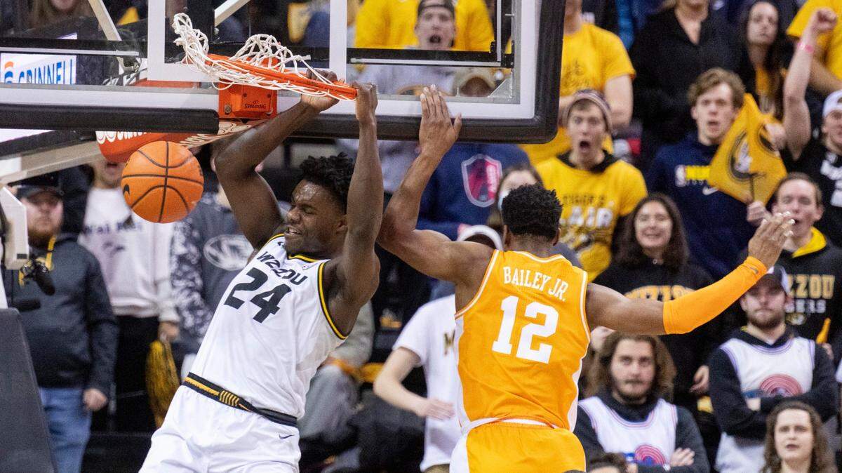 Missouri’s Kobe Brown (left) dunks past Tennessee’s Victor Bailey Jr., right, during the first half of an NCAA college basketball game Tuesday, Feb. 22, 2022, in Columbia, Mo.