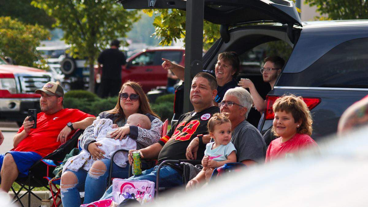 A group of people watch a parade for Tucker Langford, a 3-year-old battling terminal illness, on Saturday, Oct. 11, 2025.