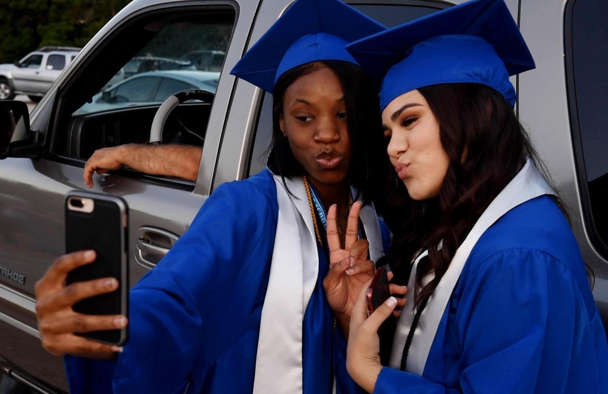 Diamond Jones, left, and Adelaida Franco, take a selfie before their graduation ceremony from Sumner Academy of Arts & Science on Thursday at the Boulevard Drive-In.