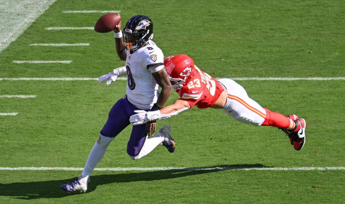 Kansas City Chiefs linebacker Drue Tranquill (23) dives to stop Baltimore Ravens quarterback Lamar Jackson (8) while he runs in the first quarter on Sunday, Sept. 28, 2025, at GEHA Field at Arrowhead Stadium.