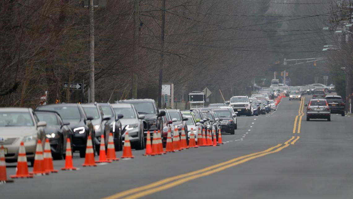 File photo of a line of cars waiting to enter a drive-thru coronavirus testing center. A woman in Texas faces a child endangerment charge after officials say she drove to a testing site with her child in the trunk.