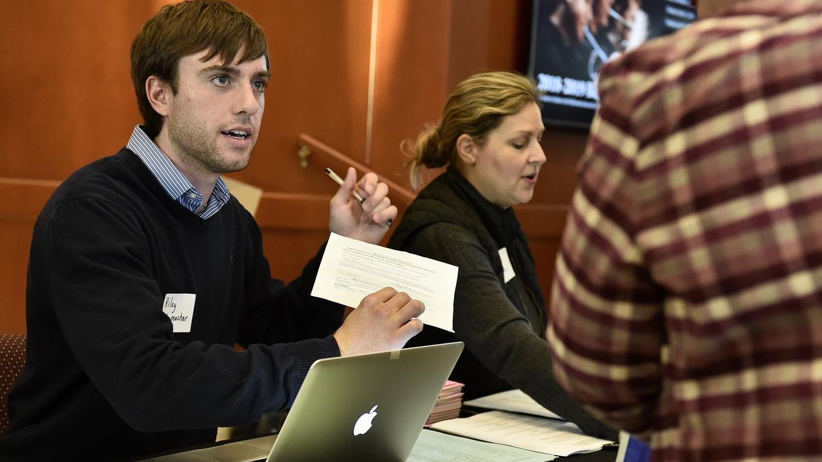 Riley Schumacher checks people in for a Johnson County Republican Party meeting in Olathe.