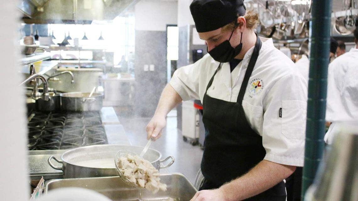 Michael Mohr, 18, scoops poached chicken out of a pot to add to the chicken pot pie filling. Mohr was working at the Broadmoor Bistro kitchen as part of the Kids Feeding Kids program, a partnership with Pete’s Garden.