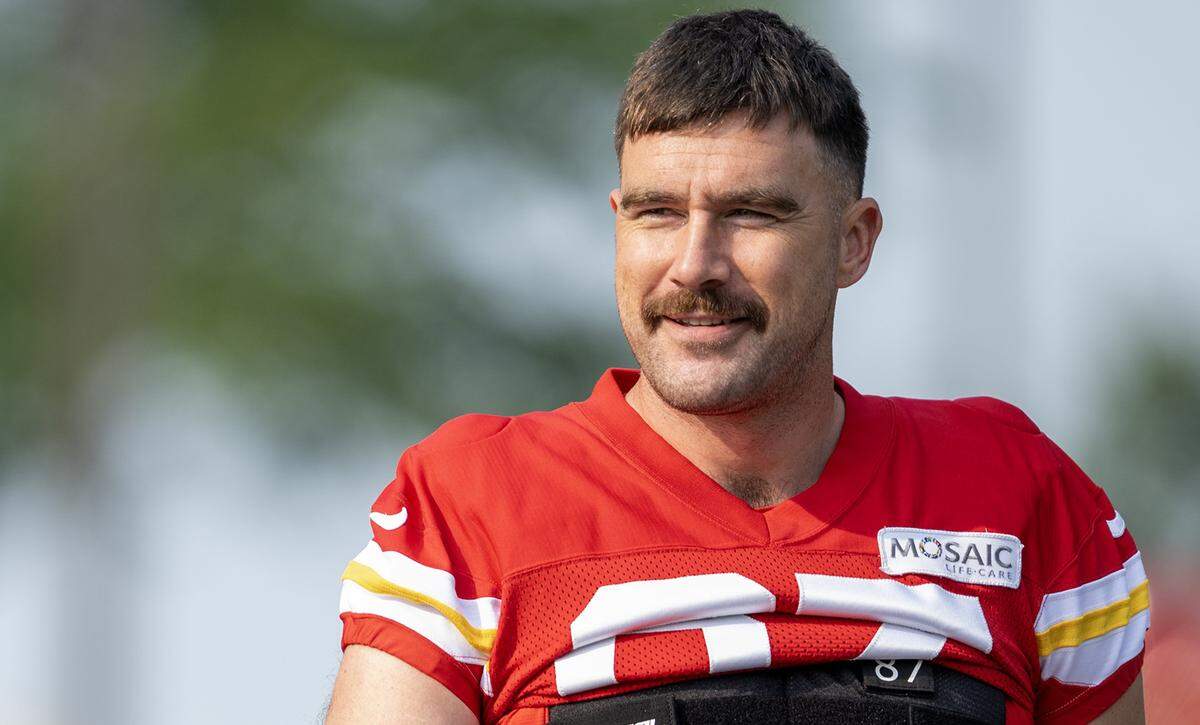 Chiefs tight end Travis Kelce, sporting darker hair and a mustache, walks to the field for training camp at Missouri Western State University on Tuesday, July 23, 2024, in St. Joseph.