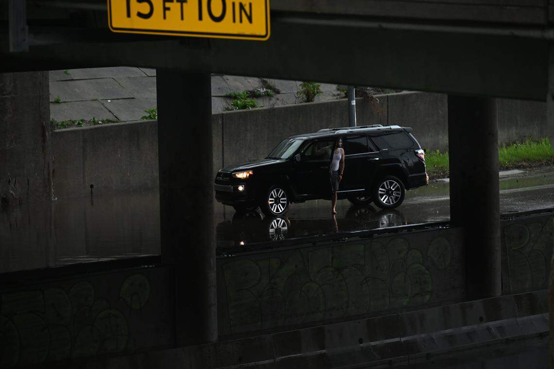 A person steps out of their car on Interstate 35 near the downtown loop amid a flash flood warning on Friday, April 17, in Kansas City.