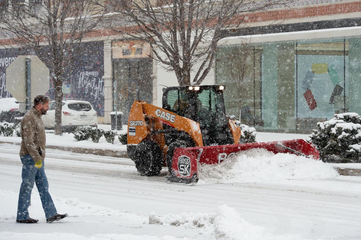 A snow plow works on the Country Club Plaza Sunday after an early winter snow storm hit the Kansas City area.