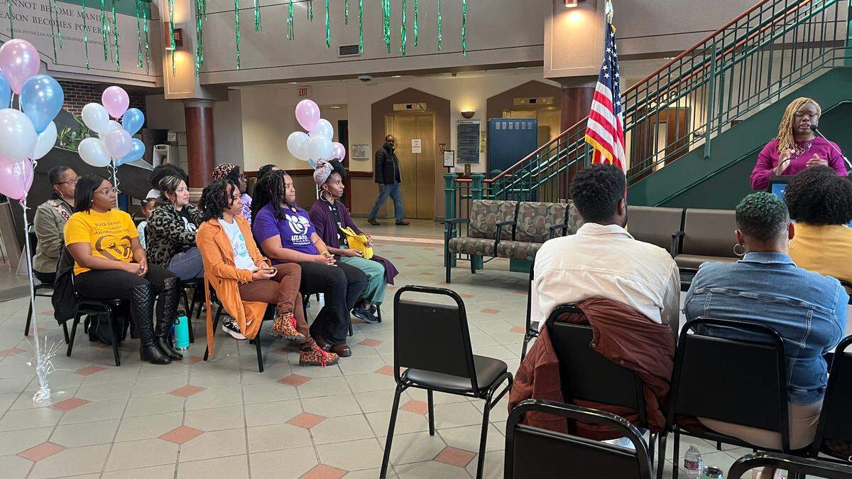 About 20 people sit in the foyer of the Kansas City Health Department on Dec. 13, 2023, listening to Dr. Marvia Jones, the director of the Kansas City Health Department, speak on the new ‘Doula Initiative,’ created to reduce pregnancy-related deaths.