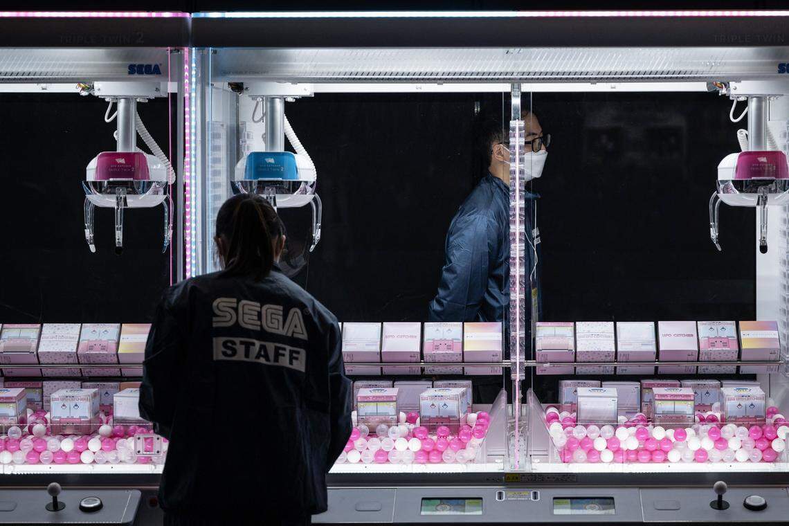 In November 2025, staff members gathered in front of claw crane game machines displayed at the booth of Japanese video game and entertainment company Sega, during the Amusement Expo 2025 in Tokyo, where crowds fill many bustling arcade halls.