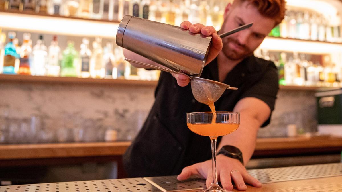 Owner Bryan Arri pours a Naked and Famous cocktail at his recently opened Fern Bar. The drink features Vago Elote, Banhez Espadin, aperol, yellow chartreuse and lime.