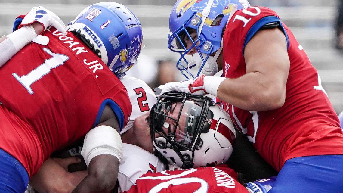 Texas Tech quarterback Behren Morton runs into a wall of Jayhawks during the first half on Saturday at David Booth Kansas Memorial Stadium.