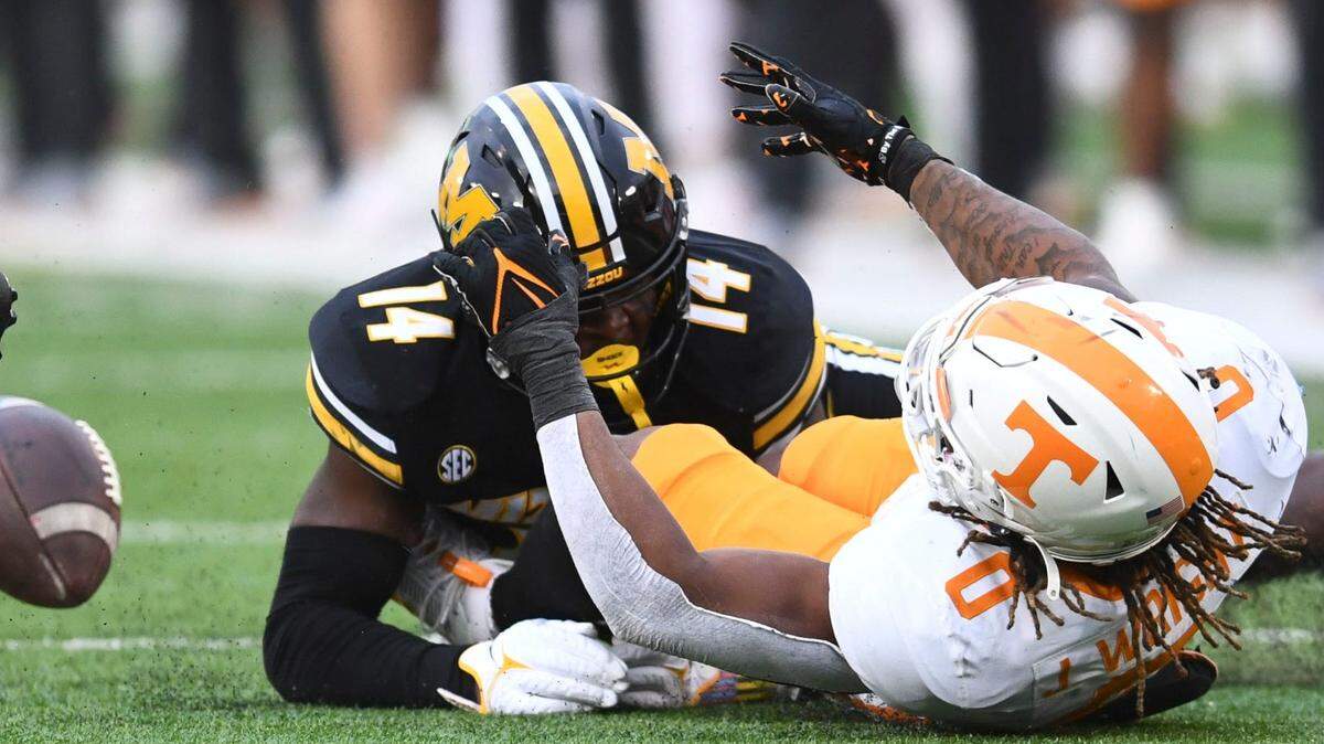 Tennessee Volunteers running back Jaylen Wright fumbles the football on a tackle by Missouri Tigers linebacker Triston Newson (No. 14) on Saturday at Faurot Field.