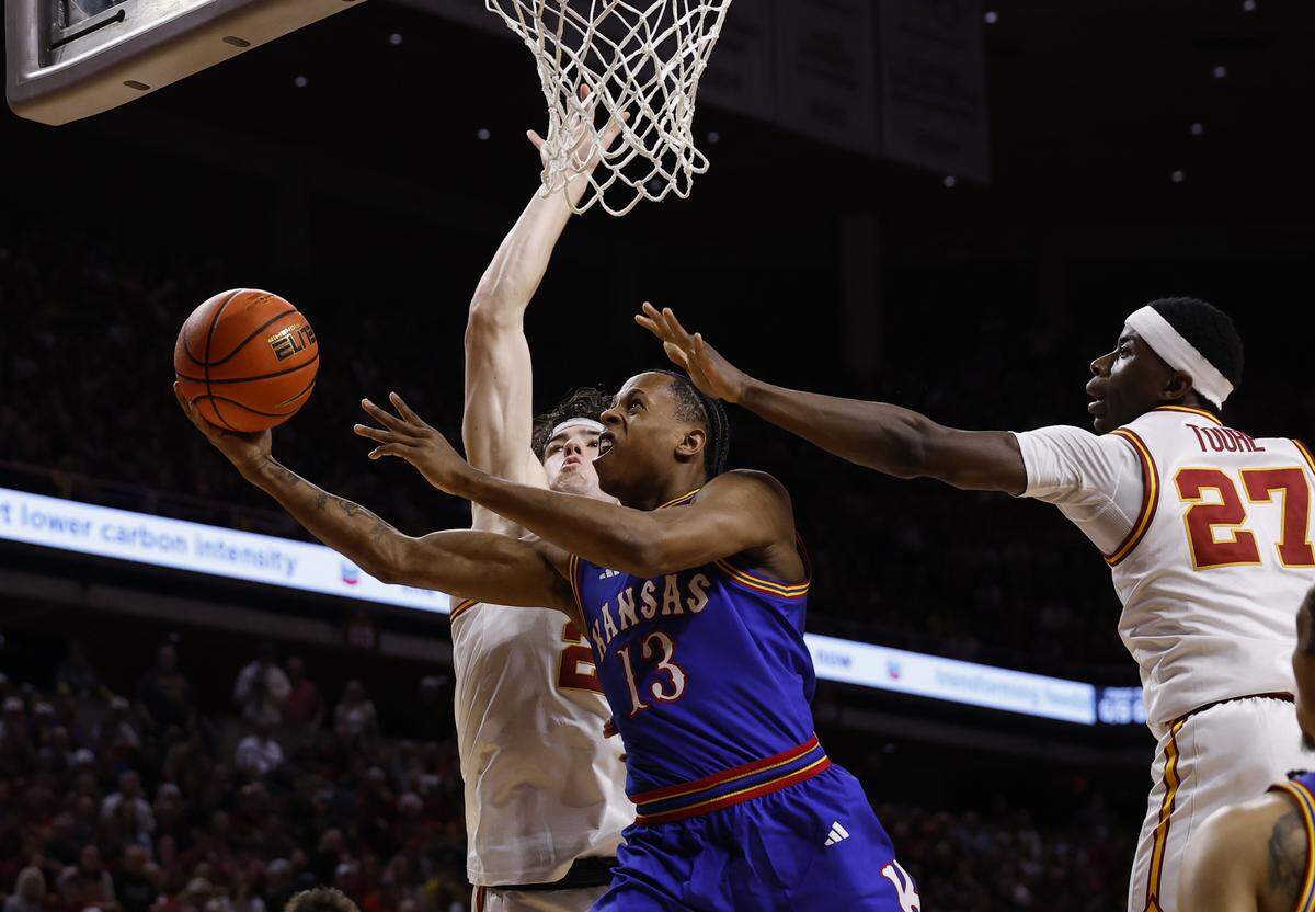 Elmarko Jackson #13 of the Kansas Jayhawks takes a shot between Blake Buchanan #23 and Killyan Toure #27 of the Iowa State Cyclones in the first half of play at Hilton Coliseum on February 14, 2026 in Ames, Iowa.