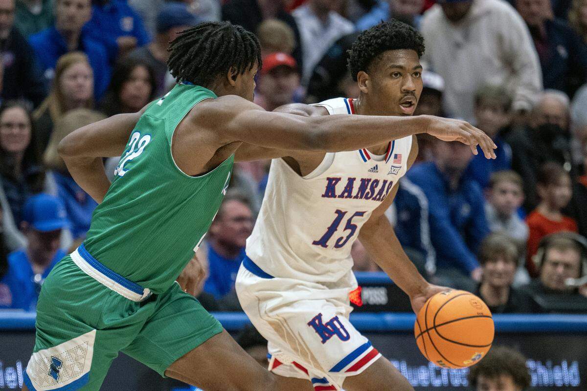 Kansas Jayhawks forward Bryson Tiller (15) handles the ball as Texas A&M-CC Islanders forward Franck Yetna (22) defends during the first half at Allen Fieldhouse on Tuesday, November 11, 2025, in Lawrence.