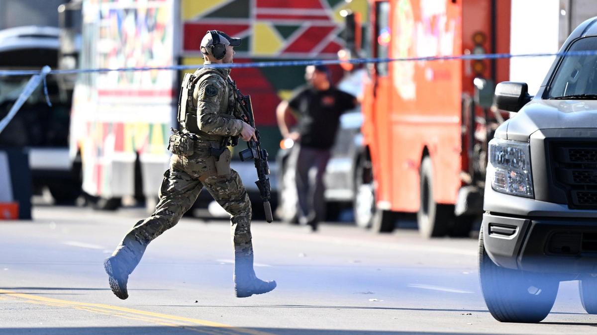 An FBI agent runs toward the west end of Union Station after a shooting following the Kansas City Chiefs Super Bowl LVIII victory parade on Wednesday, Feb. 14, 2024, in Kansas City.