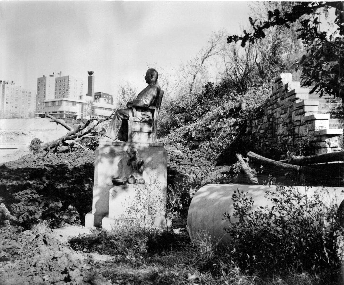 Trouble Was A-Brewing for the great hulking bronze of Alderman Jim Pendergast, on the west side of Mulkey Square, when this photograph was taken last October. Uncle Jim was sitting in the backlash of the Crosstown freeway construction job, with trees uprooted around him and sewer pipe scattered about. Shortly after the picture was taken, the Pendergast statue was placed in protective custody by the Clarkson Construction company. In the ex­treme background are the American Hereford association headquarters and Quality Hill apartment buildings.