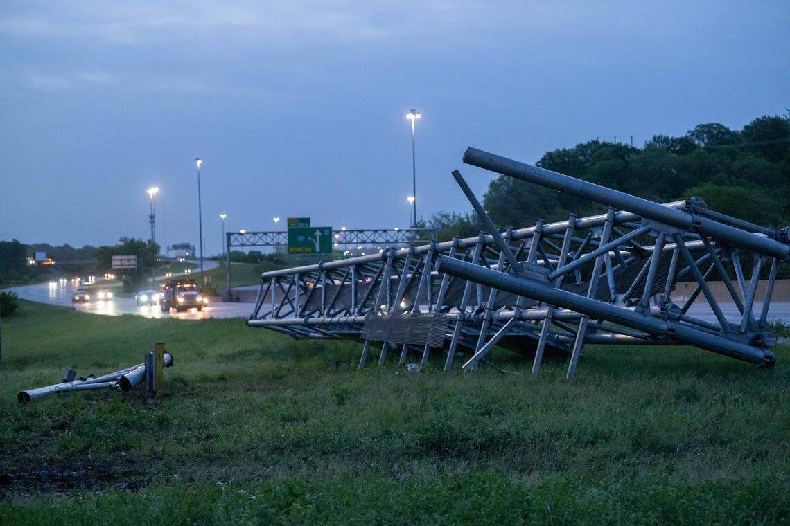 The truss from an overhead highway sign rests along the shoulder of southbound I-35 near Antioch Road in Johnson County on Friday morning after a fatal crash brought it down overnight.