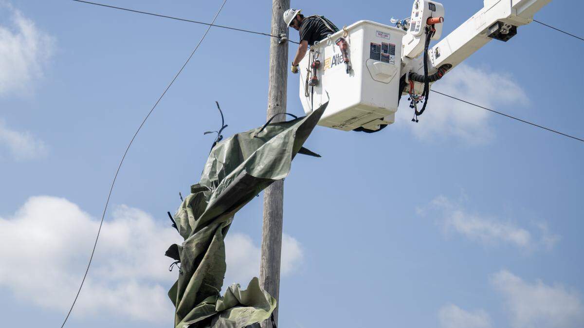 More than 7,000 customers were without power after powerful thunderstorms rolled across the Kansas City metro early Monday. In this file photo, a utility worker from Gardner, Kansas, clears debris from power lines on April 14, 2026, in Ottawa, Kansas. The city of 13,000 was hit by a tornado, leaving significant damage and power outages across the city.