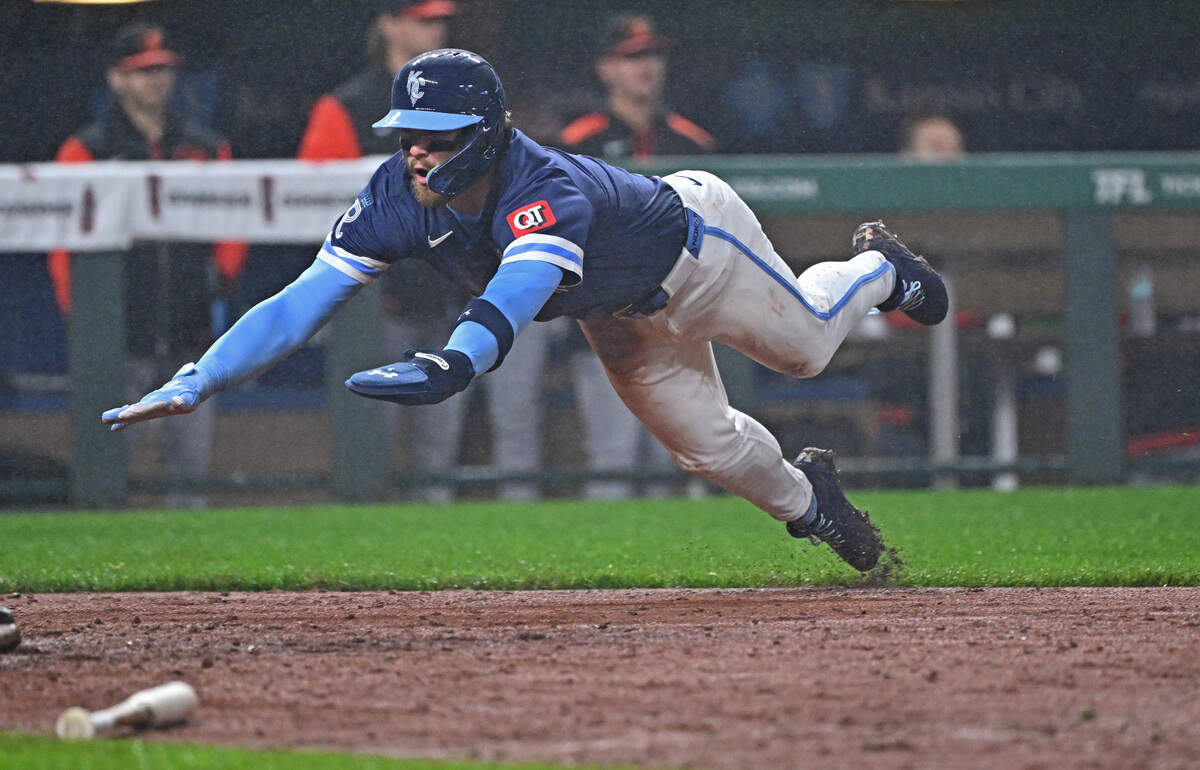 Kansas City Royals shortstop Bobby Witt Jr. (7) dives home to score a run in the eighth inning against the Baltimore Orioles at Kauffman Stadium. Witt scored on a rare bases-clearing single.