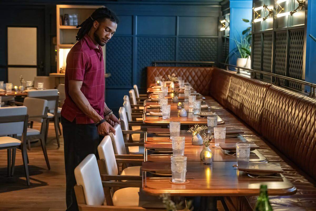 Server Travon Bray-Howard lines up the chairs in the dining room before the dinner clients arrive at The Town Company restaurant on Wednesday, March 18, 2026, in Kansas City.