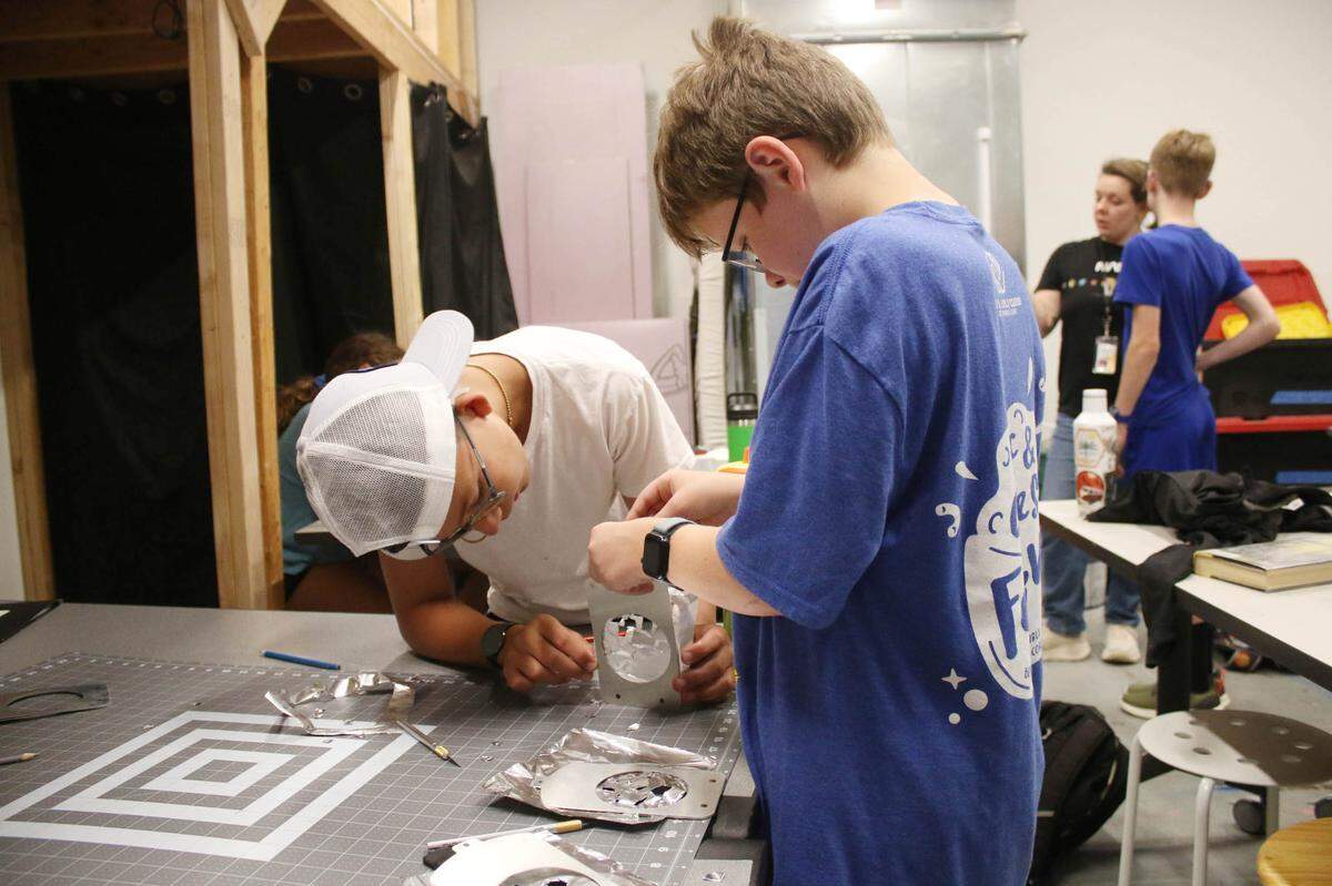 Olathe resident Boston Ward, 11, and Shawnee resident Raylan White, 12, work together to assemble their gobos during a tech theater camp at Johnson County Arts and Heritage Center. The special inserts cause a pattern to be projected when you turn on a spotlight.