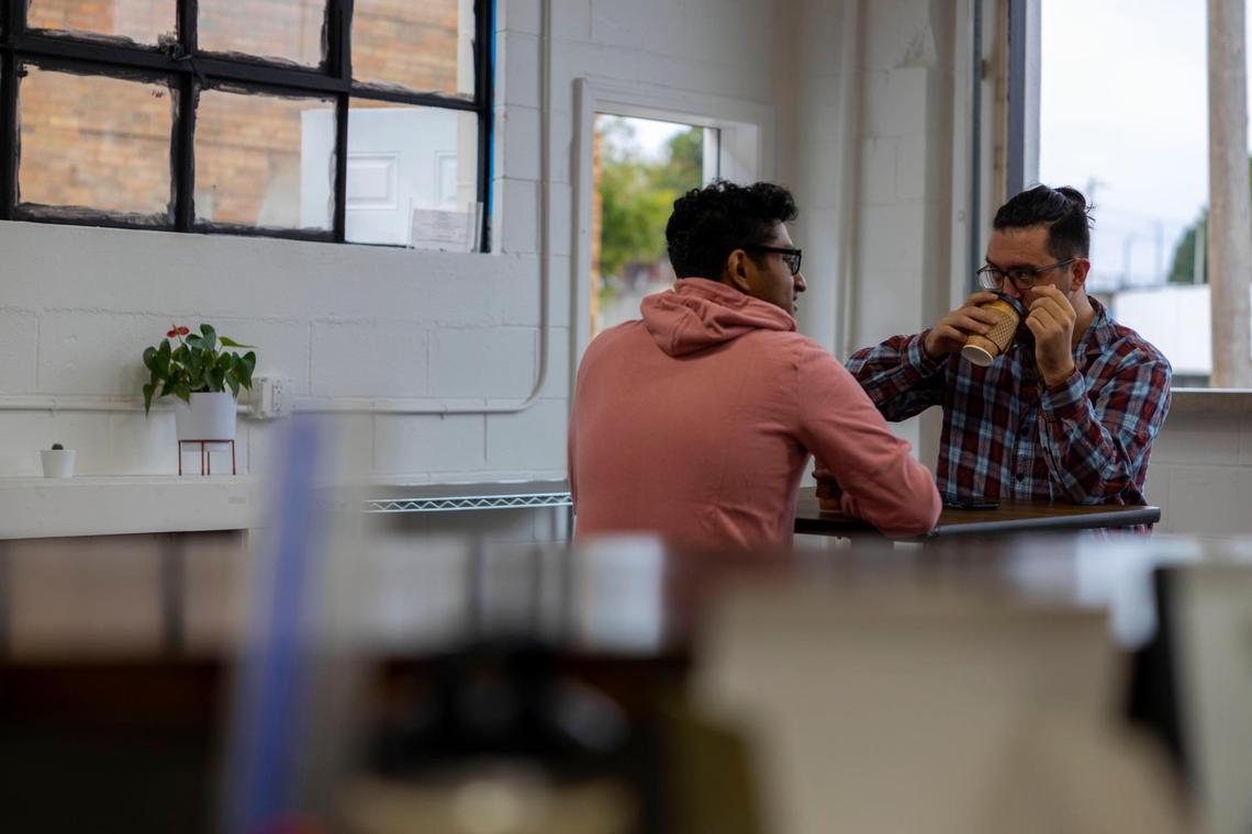 Nabil Hossain, left, and Brock Sauvage drink coffee at Kinship Cafe in Kansas City, Kansas.