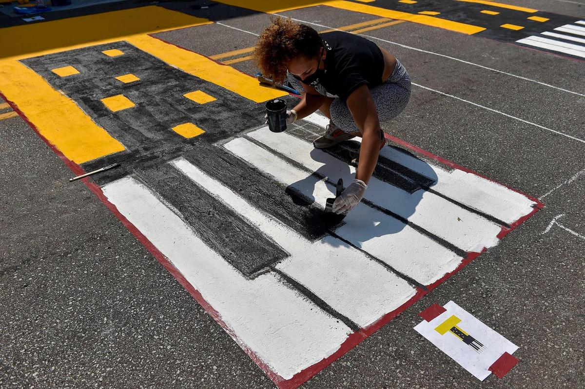 Volunteer Lacey Nicole Knight of Kansas City paints a “T” in the Black Lives Matter mural at the 18th and Vine Jazz District Saturday, Sept. 5, 2020. It is one of six being painted around Kansas City.