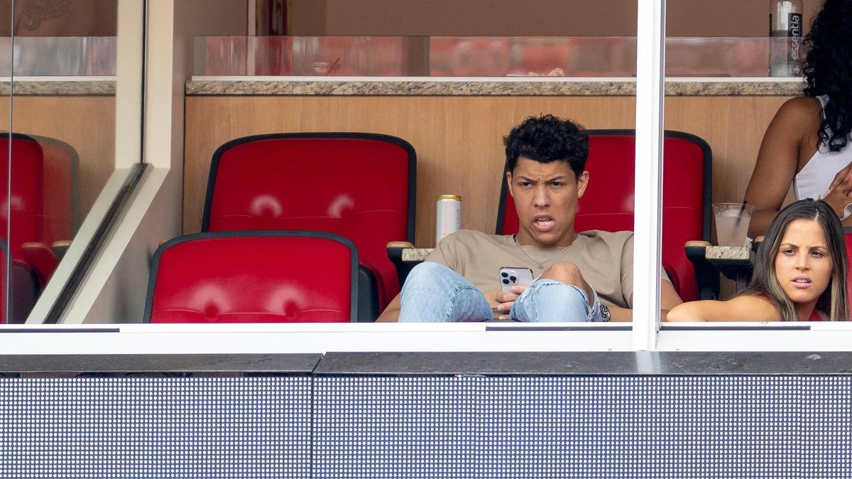Jackson Mahomes looks up from his phone during an NFL preseason football game between the Kansas City Chiefs and the Cleveland Browns on Saturday, Aug. 26, 2023, in Kansas City.