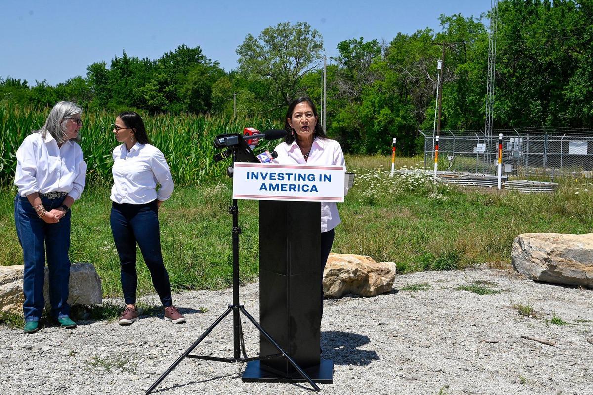 Susan Duffy, from left, Chair of Kansas Corporation Commission, speaks with Rep. Sharice Davids, D-Kan., as Deb Haaland, U.S. Secretary of the Interior, right, addresses the media during a tour to view some capped gas and oil wells Monday, July 10, 2023, at the Virginia Sue Field of Dreams at 183rd and Pflumm Rd., in Bucyrus, Kansas, in Johnson County.