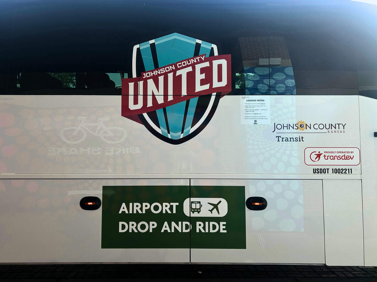A new airport shuttle service sports the Johnson County United logo, a central resource for everything World Cup in the county, on June 8, 2026. Not just for visiting FIFA fans, the bus has underbody storage and overhead storage for anyone travelling between Lenexa or Overland Park and the Kansas City International Airport.