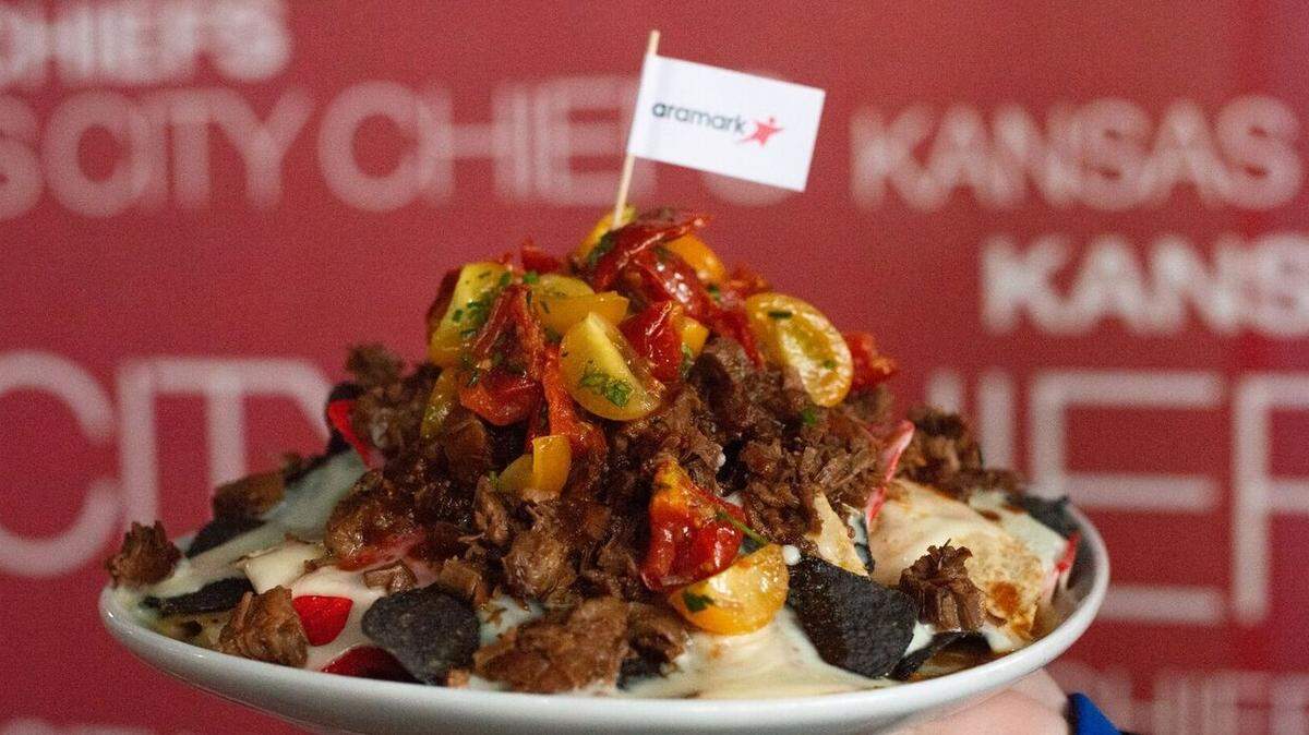 Kingdom Nachos with braised short rib nachos topped with barbecue sauce, white cheese sauce and roasted tomatoes.