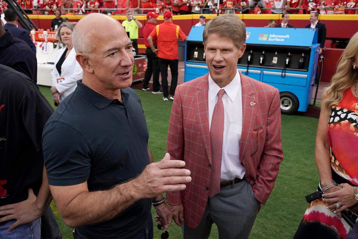 Amazon founder Jeff Bezos, left, talks with Kansas City Chiefs owner Clark Hunt before the start of an NFL football game between the Kansas City Chiefs and the Los Angeles Chargers Thursday, Sept. 15, 2022, in Kansas City, Mo.