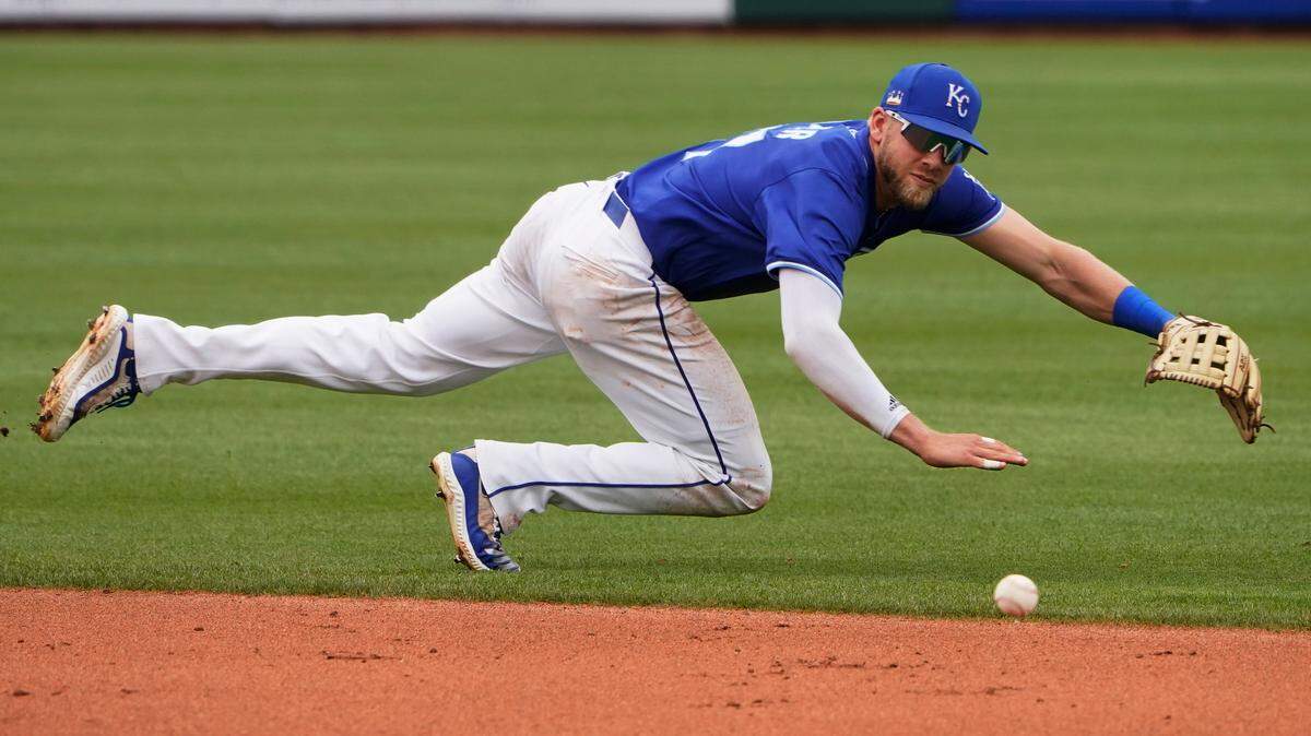 Kansas City Royals infielder Hunter Dozier dives for but can’t get to a ball hit by Arizona Diamondbacks’ Pavin Smith during the fifth inning of a spring training baseball game Thursday, March 25, 2021, in Surprise, Ariz. Whit Merrifield fielded the ball and made the throw to first for the out. (AP Photo/Sue Ogrocki)
