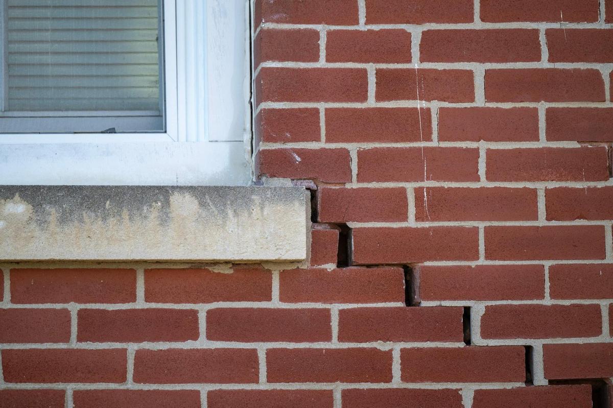 The outside wall on one of 13 infantry barracks buildings shows significant damage from basement to roof. The Michaels Organization, which handles housing at Fort Leavenworth, proposes to raze the barracks containing 98 apartments.