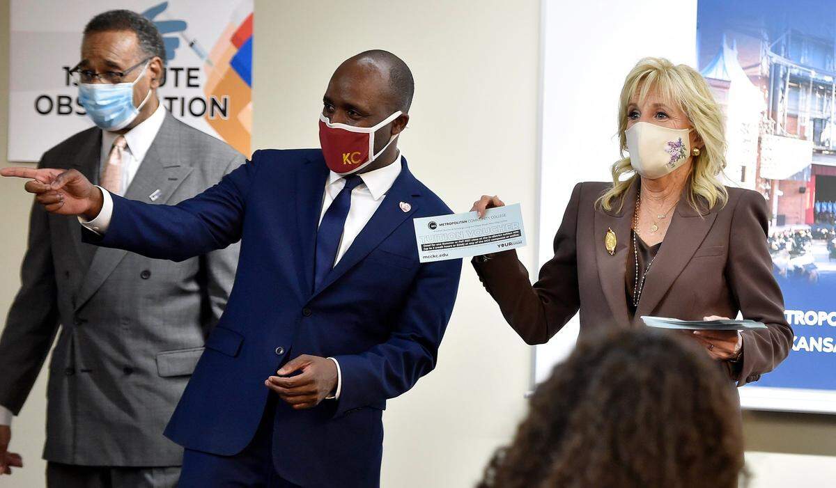 First Lady Jill Biden holds up a tuition voucher that Metropolitan Community College was offering to people who got vaccinated against COVID-19. Biden handed out the vouchers to people at the campus clinic who got vaccinated during a visit to the Penn Valley campus in Kansas City on Thursday. Biden was accompanied by U.S. Rep. Emanuel Cleaver, from left, and Kansas City Mayor Quinton Lucas on the tour.