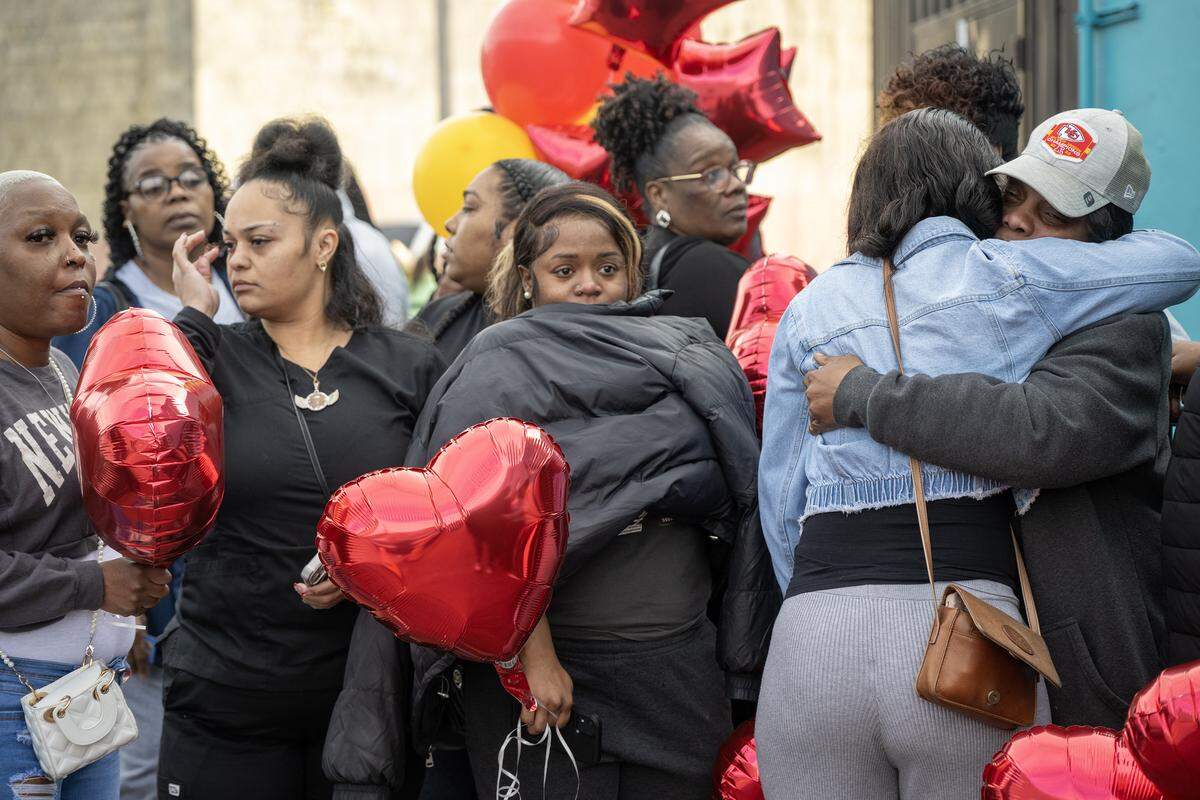 Family members waited to hug the mother of Eboni Silas, far right, during a memorial balloon release Monday, Feb. 16, 2026, in Kansas City. Family and friends gathered outside the nightclub to pay tribute to Silas, one of two women fatally shot early Sunday. Authorities identified the victims as Eboni Silas, 29, and Tishauna Ballard, 23.