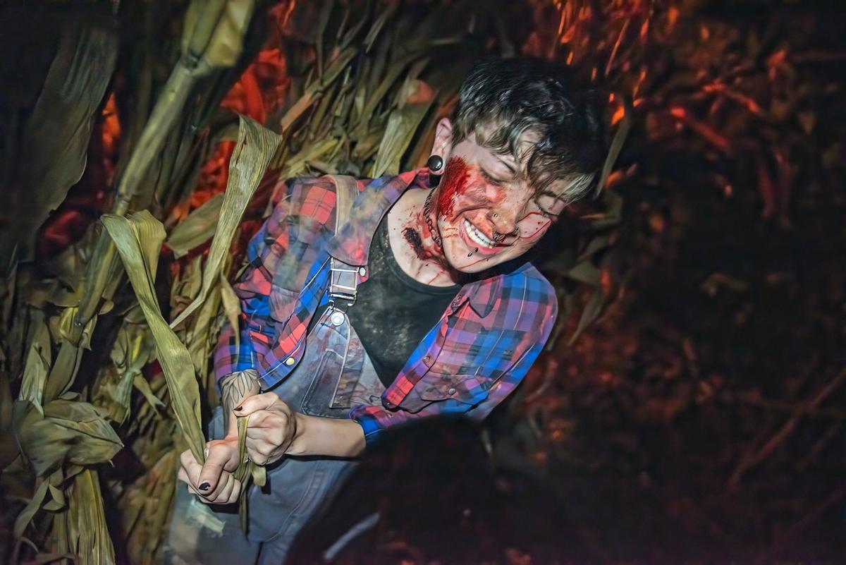 A scare actor plays the part of a captive girl along the haunted trail at Exiled KC-Crooked Rose Woods.