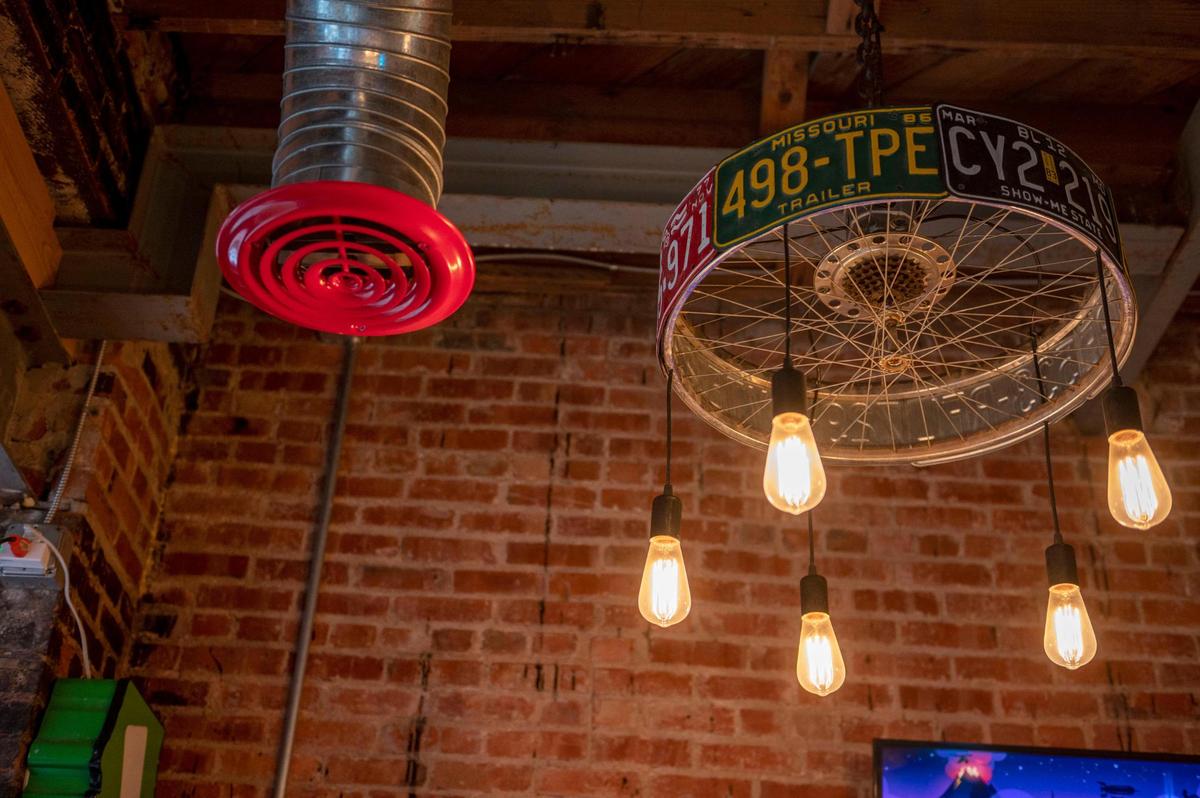 Light fixtures made out of bicycle rims and old license plates adorn Tay’s Cheesesteaks in North Kansas City.
