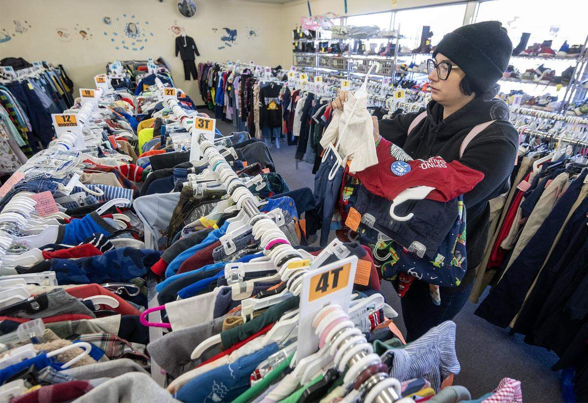Tessa Roumas of Kansas City shops for clothes for her two-and-a-half-year-old son, Theodore, at Annie's, 841 W 39th St., in Kansas City. The beloved children's resale store is being forced to close its doors because the building is being sold.