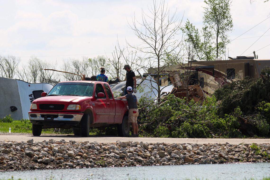People gather downed limbs from trees on April 14, 2026 after a tornado damaged trailers and RVs at Shady Acres RV Park in Hillsdale.