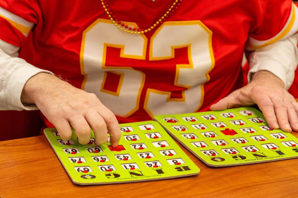 A man prepares his bingo cards for another round at the Don Bosco Senior Center on Tuesday, December 30, 2025, in Kansas City. Kansas City Chiefs Ambassadors were in attendance to help ring in the new year.