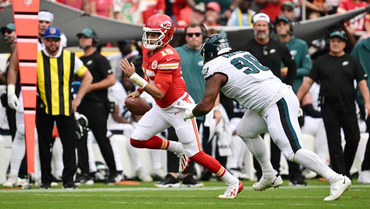 Kansas City Chiefs quarterback Patrick Mahomes (15) scrambles while being chased by Philadelphia Eagles defensive tackle Jalen Carter (98) in the first quarter on Sunday, Sept. 14, 2025, at GEHA Field at Arrowhead Stadium.