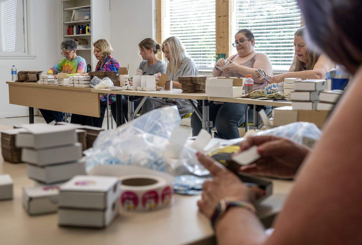 Volunteers assemble safer-sex kits containing condoms and other sexual health supplies at Our Spot KC on Thursday, June 4, 2026, in Kansas City. Planned Parenthood aims to distribute 5,000 free kits during FIFA World Cup matches in the Kansas City area.