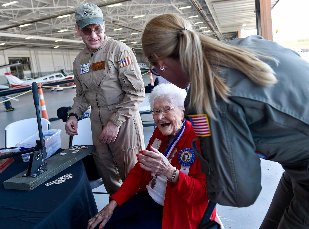 Emma Newland of Lee’s Summit shares a light moment with pilot Delane Buttacavoli while driving rivets into dog tags with the help of Dan desko, president and CEO of the B-25 History Project. Rosie’s Reply, a B-25D bomber built at the North American Aviation plant in Fairfax, arrived at Charles B. Wheeler Downtown Airport Monday, Oct. 4, 2021, the first time it has been back to Kansas City since it flew out for World War II. Newland was a Rosie who helped build the bomber at Fairfax.