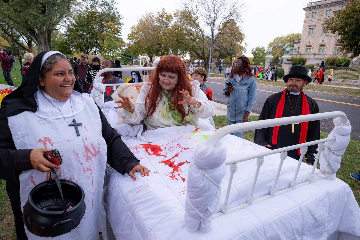 Iranitzy Perez, center, dressed as Regan MacNeil in the bedroom scene from the horror film The Exorcist, complete with a bed. Her parents, Edwardo Perez and Paola Marquez, dressed as a priest and nun by her side. They attended the Scare-It Halloween on Friday night. The event, one of Kansas City’s longest-running and largest neighborhood Halloween events, celebrated its 30th and final Halloween on Friday.