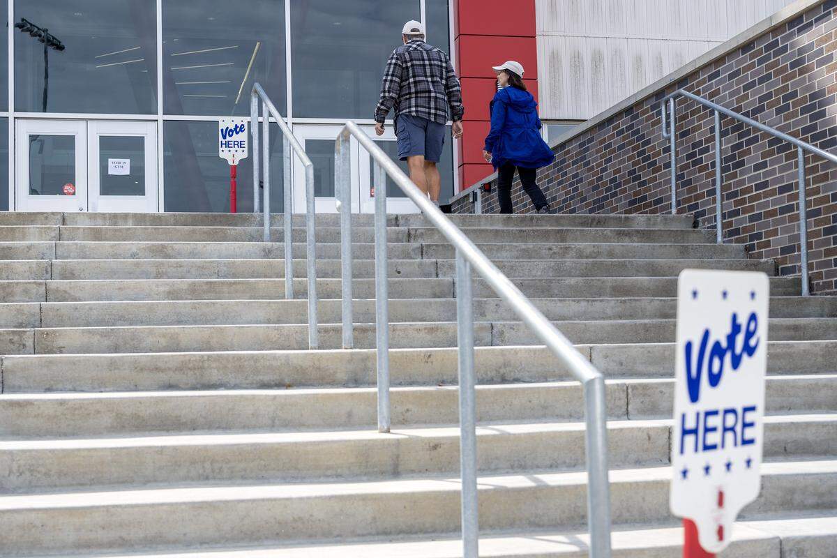 People walk up the steps to the gym at Van Horn High School during Election Day on Tuesday, April 7, 2026, in Independence.