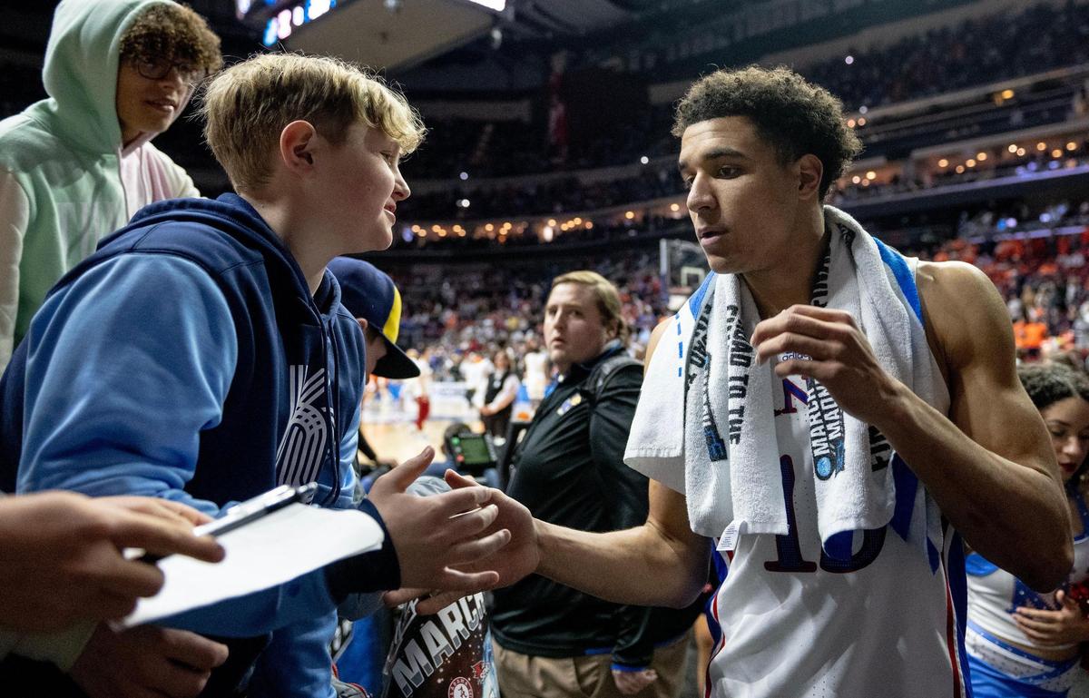 Kansas guard Kevin McCullar Jr. (15) greets a fan after defeating Howard 98-68 in a first-round college basketball game against Howard in the NCAA Tournament Thursday, March 16, 2023, in Des Moines, Iowa.